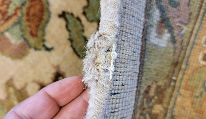 Close up view of frayed rug edge