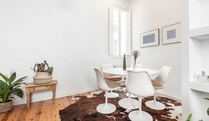 cowhide rug on the floor of a dining room